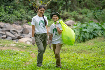 Volunteer Asian and children are collecting plastic bottles that flow through the stream into...