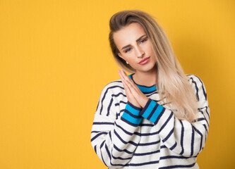 Please. Prayer woman holds her hands in a prayer gesture, begging for something, isolated on yellow background. Please concept