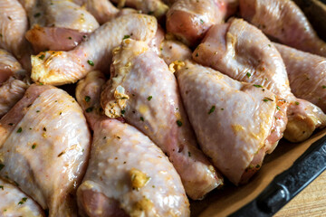 raw chicken drumsticks on baking tray prepared for oven