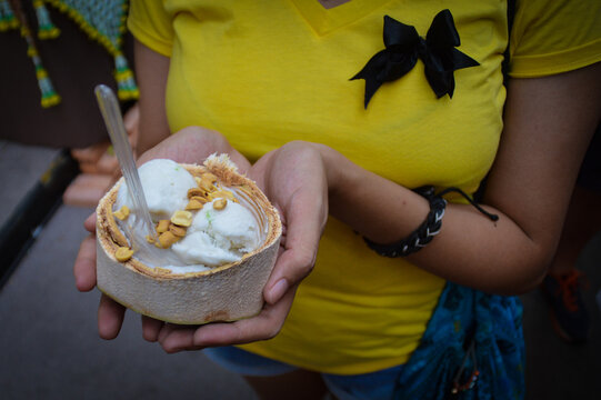Tourist holding up a vegan thai coconut icecream or itim gati