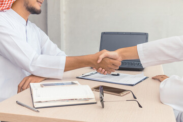 Obraz premium Muslim business team handshake together to agree joint for business at the office.