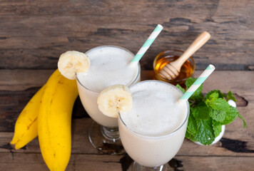 Banana fresh cocktail vanilla smoothies  fruit juice beverage healthy the taste yummy in glass drink episode good morning on wooden background from the top view.