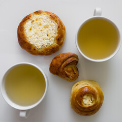 Two cups of hot tea with delicious buns for tea party on cold morning