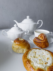 Cup of hot tea with delicious buns for tea party on cold morning