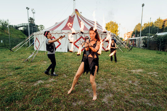 Male and female fire dancers practicing at circus