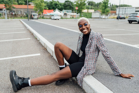 Young woman smiling while sitting at parking lot