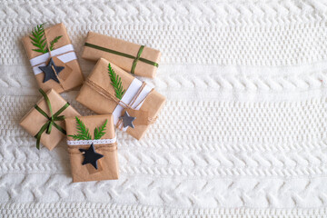 Vintage gift boxes on white background. Eco style gift wrapping: natural rough paper, jute rope, gift signing labels, branches of a christmas tree for decor. Top view, copy space.