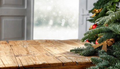 Wooden table with blank, open window and moody christmas background 