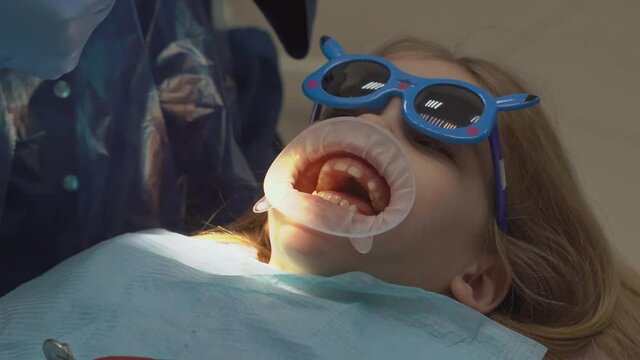 kid girl with oral dilator at dentist's appointment. treatment of teeth