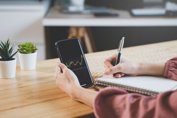 stock trade at home.  Close up hand of person learning and analyzing the chart of stock market via application