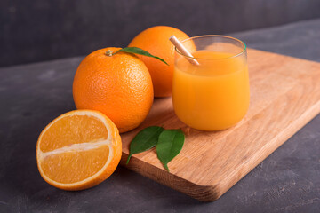 Glass of orange and juice and slice of orange fruit on wooden desk