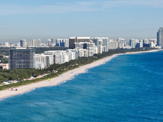 aerial of shoreline in miami beach with waves, buildings, hotels, and people on vacation