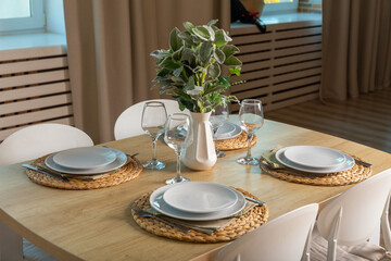 Breakfast setup on wooden table with nice vase and modern chair.