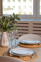 Breakfast setup on wooden table with nice vase and modern chair.
