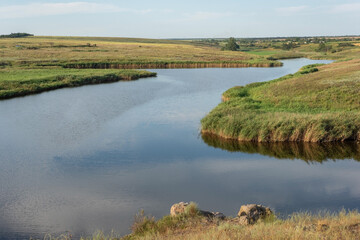 rural landscape of a field with a river on the background of a cloudy sky august ukraine