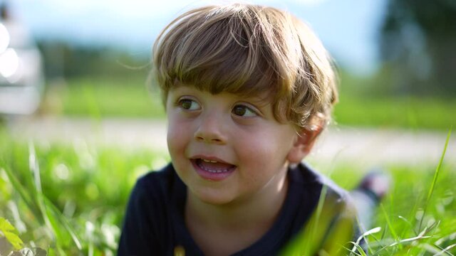 Little boy on grass portrait outside, cute little child