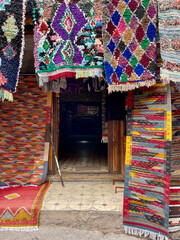 Colorful Berber carpets hanging on display at Moroccan shop in the High Atlas Mountains. Imlil...