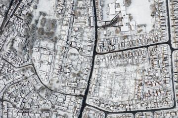 Straight down aerial photo in the winter time on a snowy day of the British town of Mirfield in Kirklees, West Yorkshire, England showing residential housing estates homes with snow covered roofs