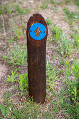 Wooden post with a blue plastic arrow pointing forward