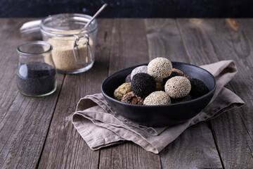 Raw energy bites balls prepared with natural ingredients on wooden background