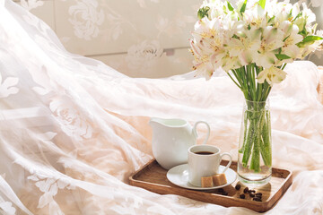 breakfast in bed with coffee and flowers on a tray. Romantic breakfast in bed.