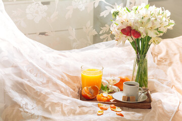 breakfast in bed with fruits, coffee and flowers on a tray. Romantic breakfast in bed