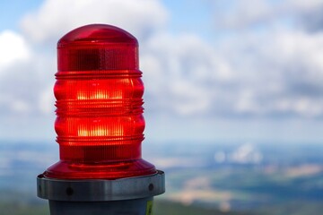 Red warning lights for air traffic on roof of high building, airport lighting equipment, daylight