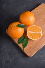 Fresh orange fruit with leaves on wooden table