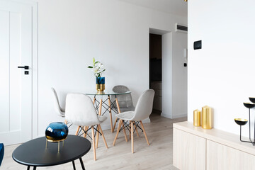 Interior with table and chairs. Modern design with stylish furniture in white room in apartment. 
