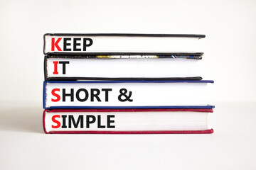 KISS keep it short and simple symbol. Concept words KISS keep it short and simple on books. Beautiful white table, white background. Business KISS keep it short and simple concept. Copy space.