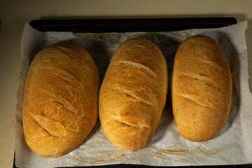 freshly baked loaves bread on a black baking sheet