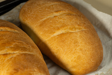 freshly baked loaves bread on a black baking sheet