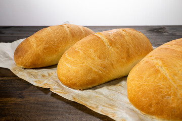 fresh baked loaves of bread on lie on a dark wooden table
