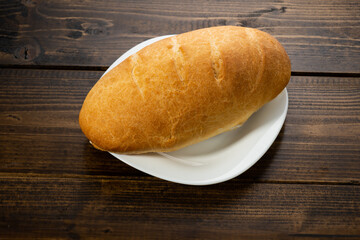 fresh baked loaves of bread on lie on a dark wooden table