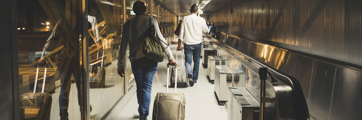People travel and walking with luggages inside airport. Flights departures or arrival travelers in banner header size - obrazy, fototapety, plakaty