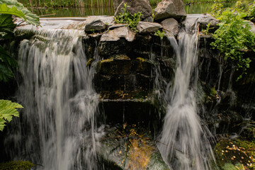 Small waterfall in public tropical garden.
