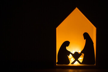 christmas native scene. shadows silhouettes of Saints Joseph and Mary and Baby Jesus made of paper with illumination