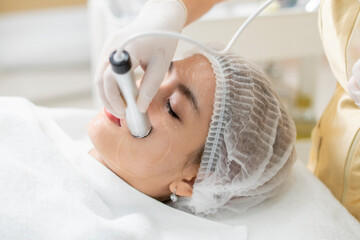 Close up the dermatologist hand apply the High intensity focus ultrasound to the woman face  for the facial treatment, rejuvenation and anti-aging.