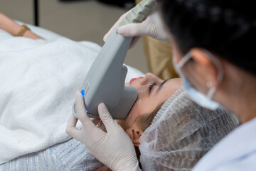 Close up the dermatologist apply the High intensity focus ultrasound to the woman face  for the...