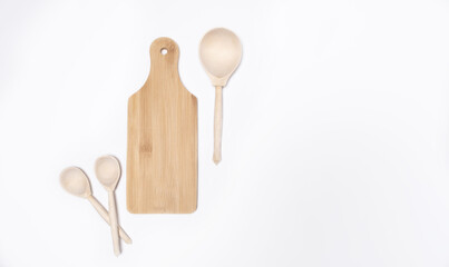 Wooden cutting board in the kitchen with spoons on a white background