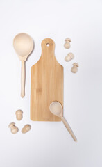 Wooden cutting board in the kitchen with spoons on a white background
