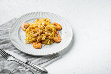 Seafood spaghetti pesto ready to eat, on plate, on white stone  surface, with copy space for text