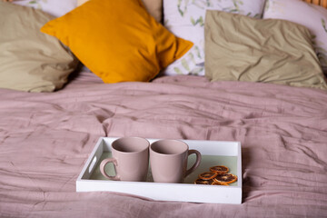 Fototapeta na wymiar Lazy morning breakfast in wooden tray on the bed blanket with coffee.