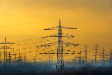 Ausbau des Stromnetzes in Deutschland: Hochspannungsmasten im Ruhrgebiet bei Sonnenaufgang