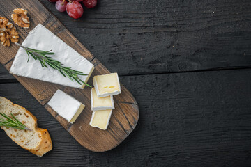 Brie type of cheese, on black wooden table, flat lay  with copy space for text