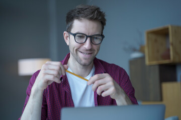 Portrait of joyful Austrian tutor in glasses having german language video classes online