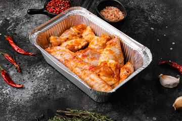 Marinated chicken wings, on black dark stone table background, with copy space for text
