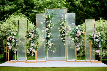 Place for wedding ceremony in garden outdoors, copy space. Wedding arch decorated with flowers....