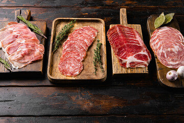 Cold smoked meat plate with prosciutto, salami, bacon, on old dark  wooden table background, with copy space for text