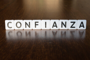 Confidence (Confianza) word on blocks. 3D Confidence (Confianza) message on wooden background with...